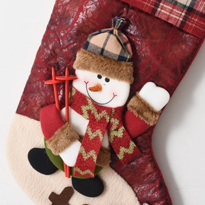 Detailed view of 3D snowman Christmas stocking with red textured fabric and plaid cuff