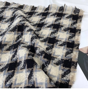 Close-up of thick houndstooth scarf with black, white, and blue fringes detail