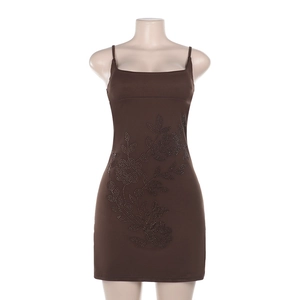 Detailed close-up of a brown mini dress featuring intricate black floral rhinestone patterns