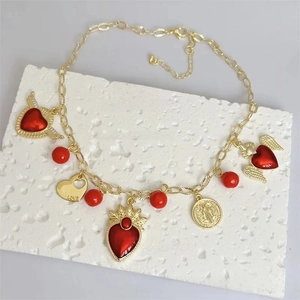 Detail of 18k gold plated necklace with red hearts, pearls, and LOVE engraved charm