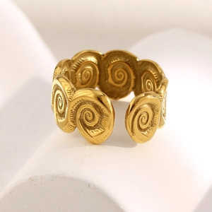 Macro shot of gold-plated spiral ring with metallic luster on white minimalist stand