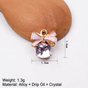 Detailed view of pink enamel bow and purple crystal pendant with 1.4cm height dimensions