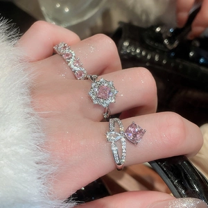 Detailed view of silver rings featuring pink zircon stones and white diamond accents