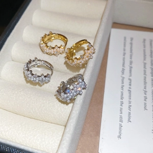 Close-up of gold and silver hoop earrings with micro pearls and cubic zirconia stones