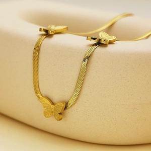 Detail of 18k gold plated snake chain necklace featuring three elegant butterfly pendants