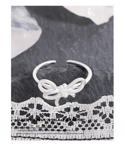Detail of S925 sterling silver bow ring featuring an intricate layered knot design