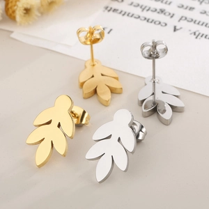 Detailed close-up of leaf-shaped titanium steel stud earrings in gold and silver finish