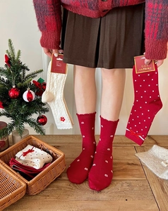 Festive red Christmas socks with white knit details and charming bow accents