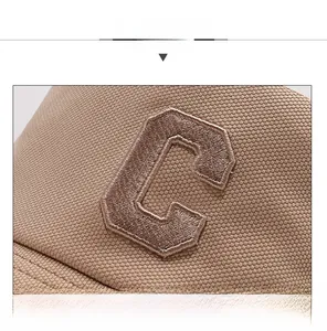 Détail du logo 'C' brodé sur le chapeau soleil kaki avec texture de tissu respirant