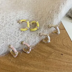 Three pairs of C-shaped bamboo earrings with sparkling crystals in pastel colors