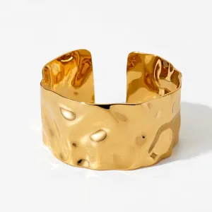 Polished gold wide cuff bracelet with artistic hammered texture and open adjustable design