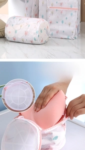 Detail of 3D cylindrical mesh laundry bag with floral print and pink zipper closure