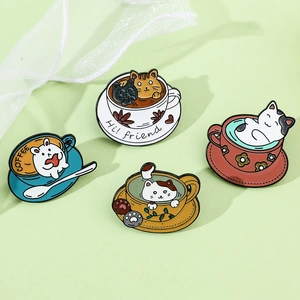 Close-up of four cute cat coffee cup enamel pins on a soft green background