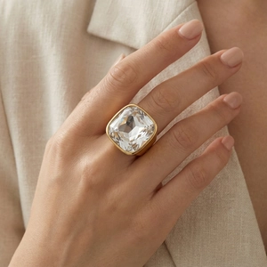 Detailed view of an oversized square clear crystal ring with elegant gold plated metal base