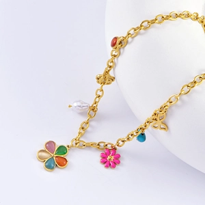 Close-up of golden necklace with colorful cat-eye flower, butterfly, and pearl charms