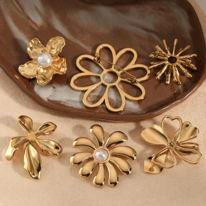 Artistic gold flower brooches set with pearls on a vintage ceramic tray for women