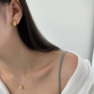 Minimalist gold water drop necklace and earring set shown on model for sizing