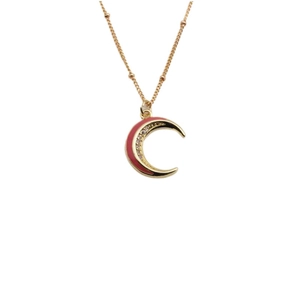 Collana a mezzaluna dorata con smalto rosa e zirconi su una sottile catena a sfere