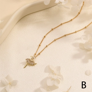 Detail of ballerina pendant with colorful zircons on golden chain over floral decor