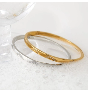 Detail showing gold and silver stainless steel bangles with embedded zircon crystals