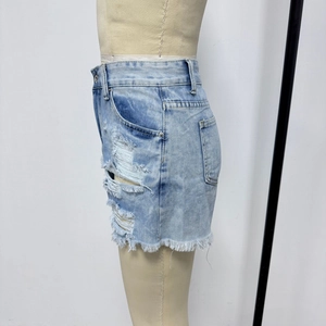 Détails de short en jean bleu clair avec trous délavés et bordures à franges effilochées