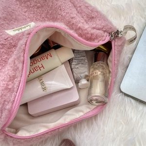 Gedetailleerd overzicht van grote roze boucle cosmetische tas met huidverzorgingsitems