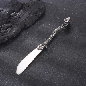 Macro shot of a creative snake-shaped stainless steel butter knife handle with rich texture