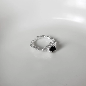 Detailed macro shot of an irregular lava-textured silver ring with black gemstone