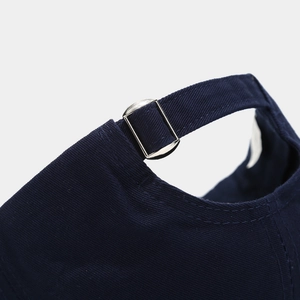 Detailed close-up of navy blue baseball cap with adjustable silver metal slider buckle