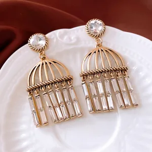 Orecchini vintage a gabbia dorata con nappe in zircone su porcellana bianca