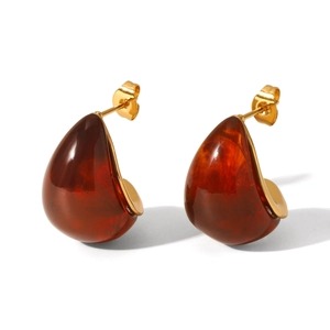 Detailed close-up of amber teardrop resin earrings with gold-plated metal settings