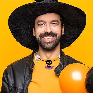 Halloween set featuring black wizard hat and skull necklace on yellow backdrop