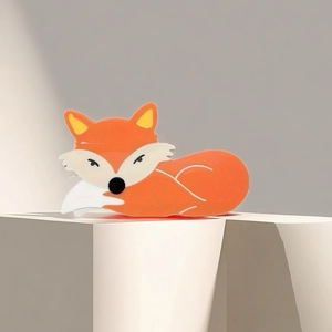 Détail de la pince à cheveux renard orange avec finition brillante sur support moderne