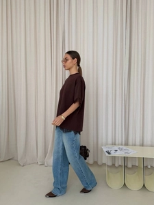 Detailed side view of loose T-shirt with lace trim and casual wide-leg denim jeans