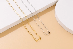 Detailed view of oval link gold and silver titanium steel necklace and bracelet set