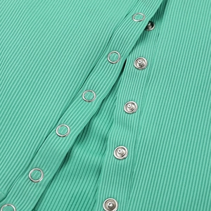 Detailed close-up of vertical ribbed texture and metal snap buttons on green tank top