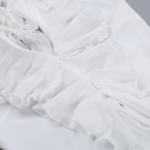 Detail shot of ruffle trim and delicate pearl buttons on a white chiffon beach top