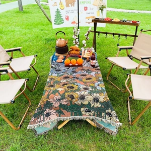 Detail of sunflower woven picnic blanket with manual fringes on an outdoor camping table
