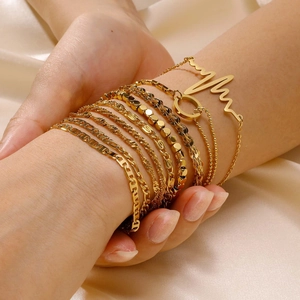 Minimalist 18K gold stainless steel layered bracelet set displayed on beige satin