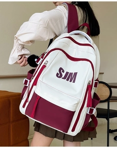 Detail of burgundy and cream contrast backpack with SJM logo and secure zippers