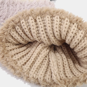 Detailaufnahme des dicken Kunstfellfutters und der groben Strickstruktur der Wintermütze