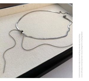Close-up of a silver-tone lariat snake chain necklace with adjustable slider bead