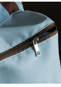 Close-up of light blue travel organizer with durable fabric and metal zipper detail