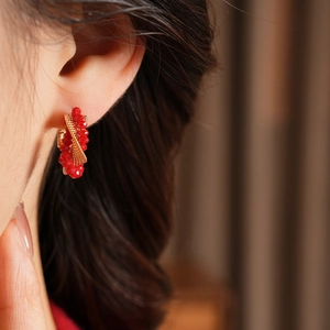 Detailed close-up of vintage twisted red glass bead earrings with golden woven net accents
