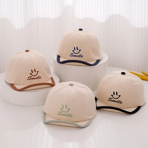 Casquettes bébé en coton avec logo souriant et visières colorées sur socles