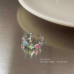 Detailed macro shot of colorful enamel flower accents on a silver adjustable open ring band