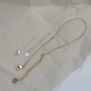 Detailed macro view of 925 sterling silver and gold snake chains with lobster clasps