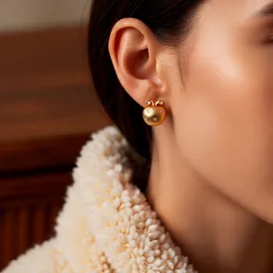 18K gold-plated apple stud earrings with sparkling stones shown on a model