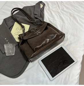 Vista piatta della borsa tote in pelle PU testa di moro con catena e chiusura in metallo