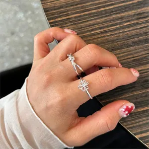 Detailed view of S925 sterling silver knot and flower rings worn on a model's hand